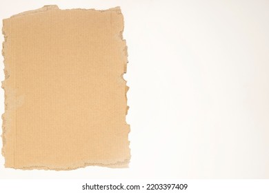 A Piece Of Torn Cardboard Box With Space For Text, Located To The Left On A White Background.