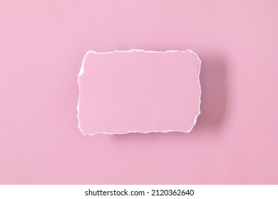 Piece of torn pink note with shadow. Torn, ripped paper on pink background. Blank pink paper with torn edges. Flat lay, top view, copy space
