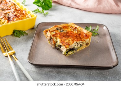 A piece of traditional homemade Lorraine pie with chicken, broccoli and mushrooms on a table