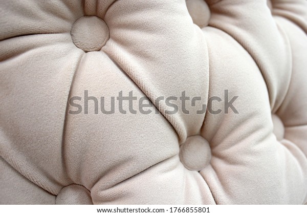 A piece of upholstered furniture with a classic\
Chesterfield pattern with buttons. Modern furniture fabric.\
Close-up photos, selective\
focus.