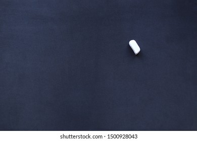 Piece of white chalk on the school blackboard background