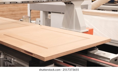 A piece of wood is being cut by a machine. The wood is brown and has a grain pattern - Powered by Shutterstock