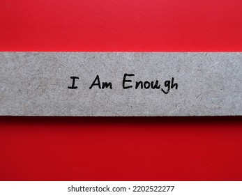 Piece Of Wood On Red Background With Handwritten Text I Am Enough - Positive Self Talk Affirmation Mantra To Boost Self Belief And Self Esteem