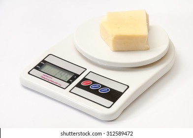 A piece of yellow cheese on a kitchen digital scale.