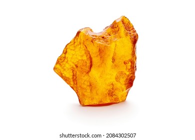A piece of yellow opaque natural amber classification color Clear Succinite, has superficial cracks on its surface. Placed on white background. Stock Photo
