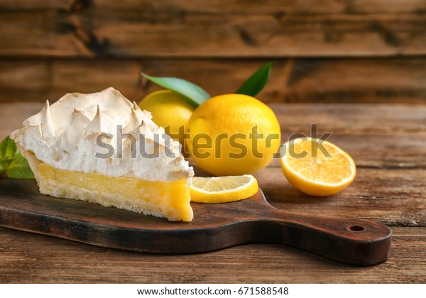 Piece of\
yummy lemon meringue pie on wooden\
table