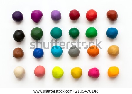 Pieces or balls of Colorful plasticine clay for modeling isolated on white background. Top view with shadow. Creativity children toys concept. 24 colors set.