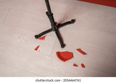 Pieces of a broken plate on the floor, scattered around a stool stand