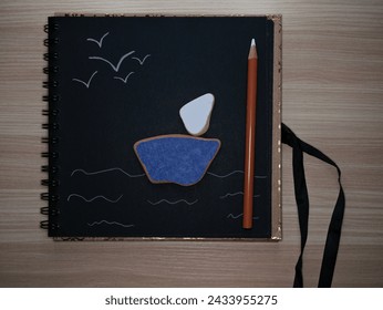 Pieces of ceramic tiles shaped like a sailboat with painted elements on black background.