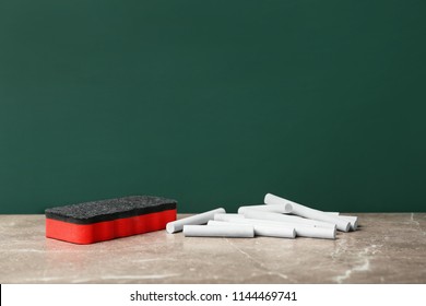 Pieces Of Chalk And Duster On Table Near Board