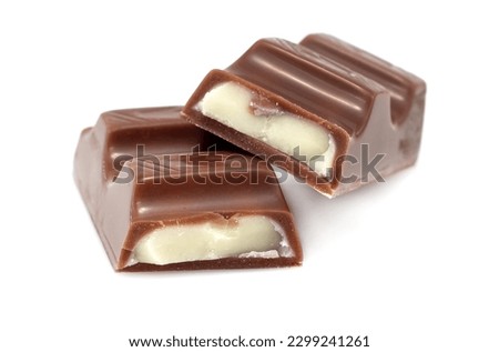 Pieces of chocolate with soft milk filling on a white background. Chocolate bar. Pastry