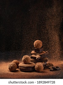 Pieces Of Chocolate With Sweets Truffle With Air Flying Cocoa Powder On A Dark Background.