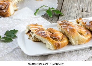 Pieces of a Christmas Cinnamon Wreath dessert with a holly twig on a white tray