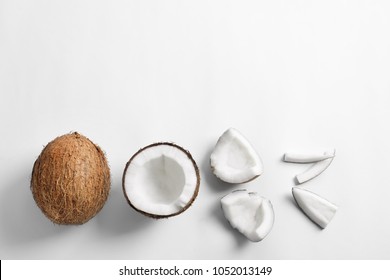 Pieces of coconut on white background, flat lay