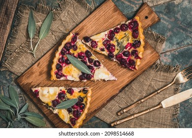 Pieces Of A Cranberry Goat Cheese Tart With Sage On Rustic Background, Top View