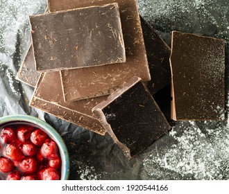 Pieces Of Dark Chocolat Bars And Cherries On Black Texture