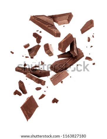 Pieces of dark chocolate falling close up on a white background
