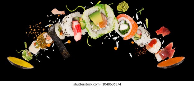 Pieces of delicious japanese sushi frozen in the air. Isolated on black background