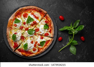 Pieces of delicious Mexican pizza with cherry and rosemary. On dark rustic background