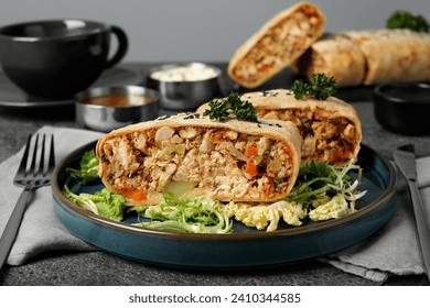 Pieces of delicious strudel with chicken and vegetables served on grey textured table, closeup
