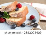 Pieces of freshly baked sponge cake and berries on table, closeup