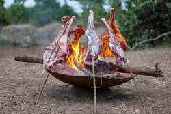 Pieces Of Goat Meat Being Cooked The Traditional Way Over And Open Fire In The Masai Mara. It Is Maasai Hospitality To Share A Slaughtered Goat With Friends.