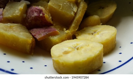 Pieces of ground provisions. Square pieces of yellow sweet potato and round pieces of ripe plantain on a plate.   - Shutterstock ID 1945907284