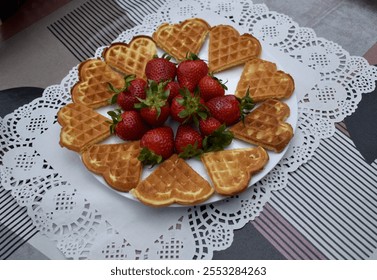 Pieces of heart-shaped waffles and strawberries on a white plate and colourful table. - Powered by Shutterstock