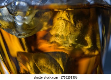 Pieces Of Ice Cube In Whiskey. Close Up Macro Of Ice Cubes In Glass Drink Or Another Alcohol. Abstract Texture Background