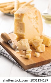 Pieces Of Italian Parmesan Cheese. Block Of Parmesan On White Table.