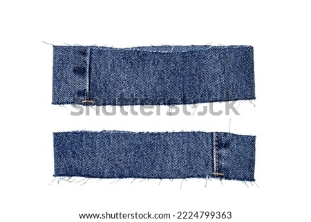 Pieces of jeans fabric with fringe isolated on white background. Two cut-off pant leg pieces of a blue denim jeans. Macro.