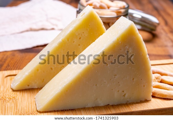 Pieces of matured\
pecorino romano italian cheese made from sheep milk in Lazio,\
Sardinia or Tuscany close\
up