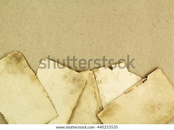 Pieces of old\
paper on a cardboard\
background