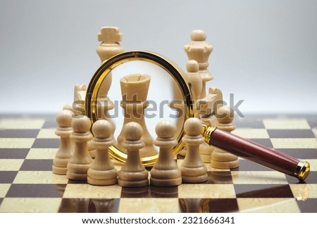 The pieces on the chessboard and the magnifying glass between the pieces