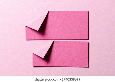 Pieces of paper notes or sheets with folded edge dog-ear earmark and copy space for text on light pink background, top view flat lay