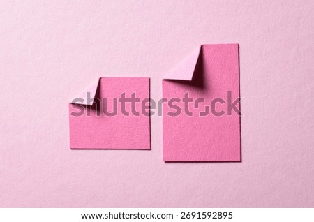 Pieces of paper notes or sheets with folded edge dog-ear earmark and copy space for text on light pink background, top view flat lay