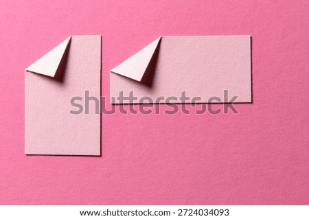 Pieces of paper notes or sheets with folded edge dog-ear earmark and copy space for text on pink background, top view flat lay