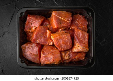 Pieces of pork or beef meat for barbecue marinated in spices and chilled in a disposable package, ready for sale, for eating, or long-term freezing