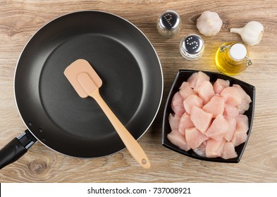 Pieces Of Raw Chicken Meat In Bowl, Frying Pan, Vegetable Oil And Condiments On Wooden Table. Top View