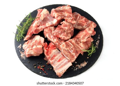 Pieces of raw meat on a round black stone plate on a white background, Fresh meat with bones
 - Powered by Shutterstock