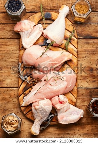 Pieces of raw poultry meat and spices for meat. Chicken meat on rustic cutting board