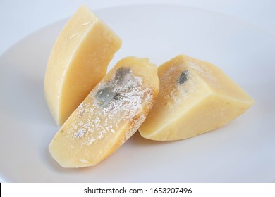 Pieces Of Rotten Cheese On A White Background