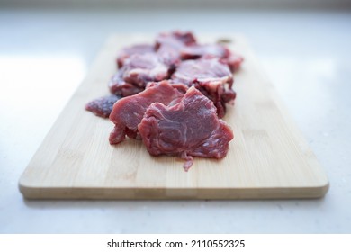 Pieces of sliced meat on a cutting board on the table. Selective focus.                               