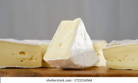 pieces of soft cheese Camembert on light grey background. Delicious pieces of white mold cheeses with soft textures Camembert close up, macro
