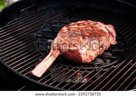 pieces of tomahawk steak on serving plate placed on a wooden table, ready to be eaten