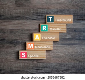 Pieces of wood with SMART, specific, measurable, attainable, recorded, time-bound on wooden background - Shutterstock ID 2053687382