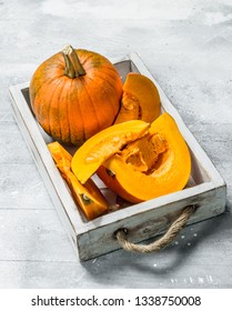 Pieces of yellow pumpkin on tray. On white rustic background - Shutterstock ID 1338750008