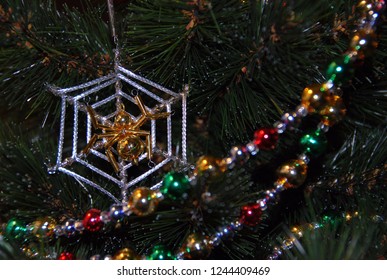 Pied bright shiny glass garland on the Christmas tree. Ornaments for a Christmas tree. Christmas decorations. Funny spider web decoration.