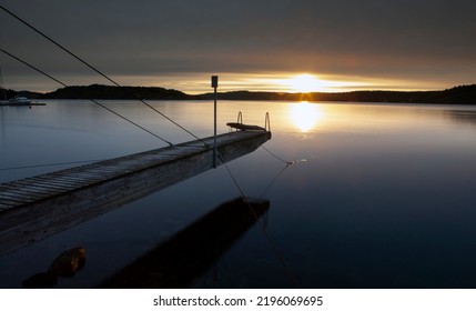 Pier and calm water in sunrise ligth in southern Norway - Shutterstock ID 2196069695