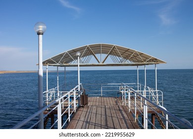 Pier With Gazebo, Wooden Deck And Lights On The Lake